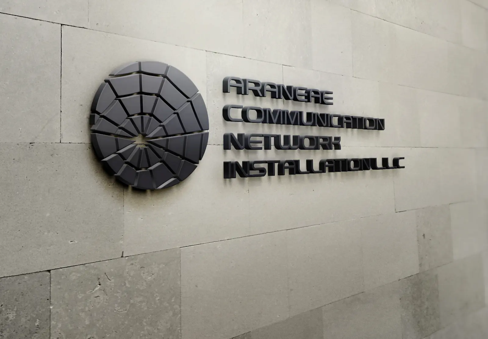 Araneae Communication Network Installation LLC office signage — 3D spider-web logo on stone wall